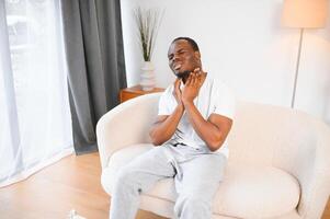 enfermo africano hombre con dolorido garganta, retrato de enfermo negro hombre sufrimiento desde dolorido garganta debido a frío, gripe, alergia foto