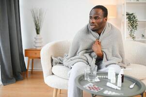 Shot of a young man with a cold recuperating at home photo