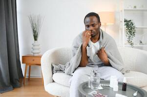 ill african american man in warm scarf with nose spray photo