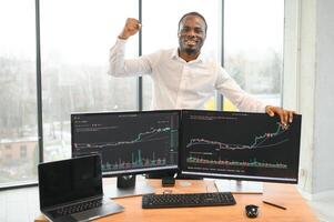 African-American broker works in office using workstation and analysis technology photo