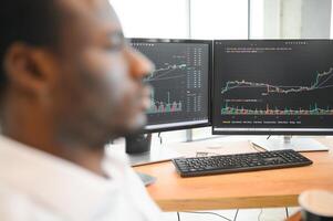 African-American broker works in office using workstation and analysis technology photo