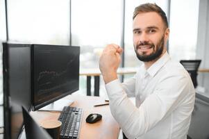 Crypto trader sits at his workplace in front of a monitor with charts. photo