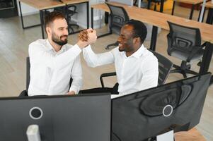 Two happy successful excited diverse traders investors giving high five celebrating successful stock exchange trading deal photo