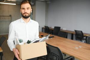 Man by dismissal. Guy lost job. Fired manager in company. Dismissal box in hands of employee. photo