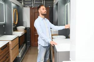 Man choosing bathroom sink and utensils for his home photo