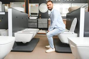 Man choosing home toilet in store photo