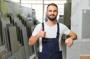 Plumber in uniform at showcase in plumbering store photo