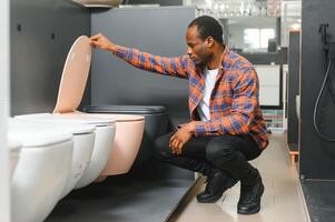 African american Man choosing home toilet in store photo