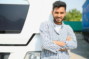 Young indian man standing in front of his truck. photo