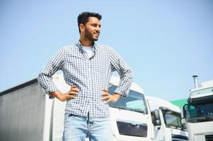 Young indian man standing in front of his truck. photo