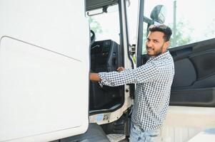 Portrait of confident indian truck driver on parking. Copy space. photo