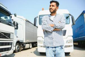 Young indian man standing by his truck. The concept of freight transportation. photo