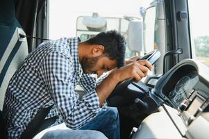 Exhausted truck driver falling asleep on steering wheel. Tiredness and sleeping concept photo