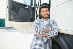 Young indian man standing by his truck. The concept of freight transportation. photo