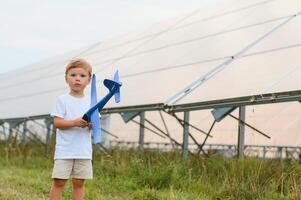 un pequeño chico es teniendo divertido cerca el solar paneles el concepto de solar energía. foto