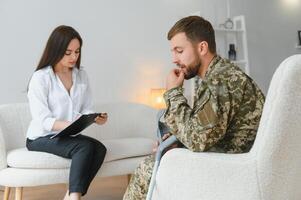 Sad male soldier on appointment with psychologist at office photo