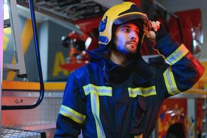 Photo of fireman with gas mask and helmet near fire engine