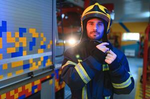 bombero retrato en deber. bombero con casco cerca fuego motor foto