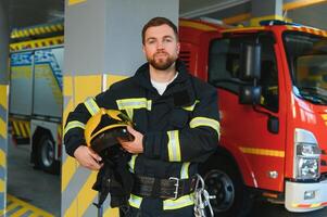 Portrait of male firefighter in uniform at fire station photo