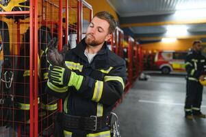 A firefighter puts on a fire uniform at the fire department photo