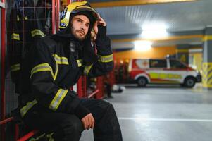 retrato de masculino bombero en uniforme a fuego estación foto