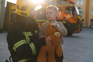 Portrait of a fireman and a little boy with a teddy bear. photo