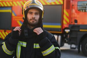 bomberos hombre en un protector traje cerca fuego camión. proteccion, rescate desde peligro. fuego estación foto