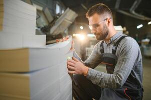 Man working in printing house with paper and paints photo