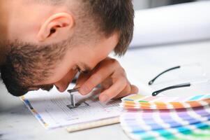 hombre trabajando en impresión casa con papel y pinturas foto