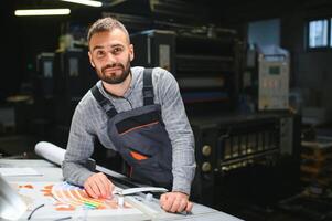 Graphic engineer or worker checking imprint quality in modern print shop photo