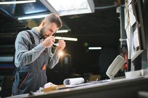 Print house worker controlling printing process quality and checking colors with magnifying glass photo