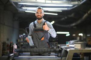 Man working in printing house with paper and paints photo