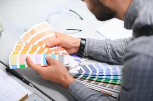 Man working in printing house with paper and paints photo