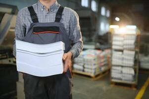 Man working in printing house with paper and paints photo