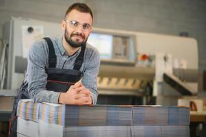 printing house, experimented technician works on UV printer. Production work photo