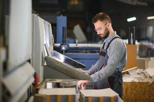Man working in printing house with paper and paints photo