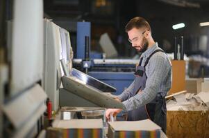 Man working in printing house with paper and paints photo