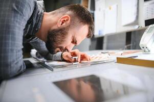 Print house worker controlling printing process quality and checking colors with magnifying glass photo