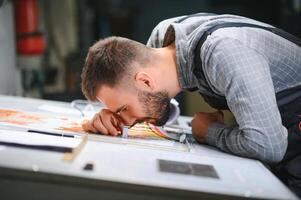 Graphic engineer or worker checking imprint quality in modern print shop photo