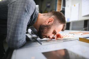 Graphic engineer or worker checking imprint quality in modern print shop photo