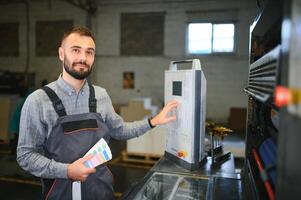 Man working in printing house with paper and paints photo