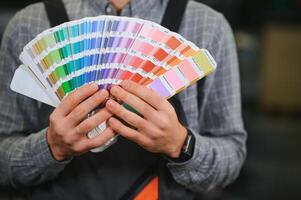 tipógrafo en pie con color muestras a el impresión fabricación foto