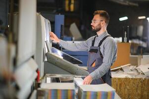 Man working in printing house with paper and paints photo