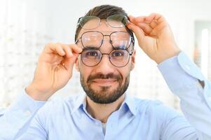 Satisfied Customer. View of happy young male client wearing new glasses photo