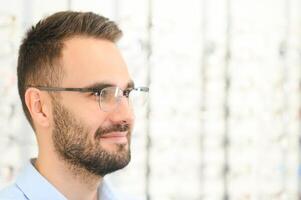 man chooses glasses for vision correction in an ophthalmology salon. Glasses for vision correction photo