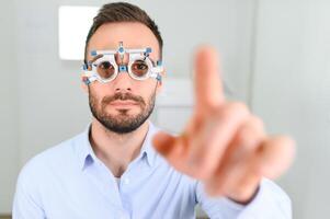 man checking up vision with special ophthalmic glasses photo