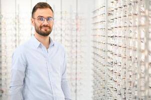 hombre elige lentes para visión corrección en un oftalmología salón. lentes para visión corrección foto