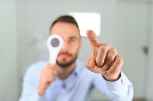 Test of sight. Man is checking his vision indoors in the clinic photo