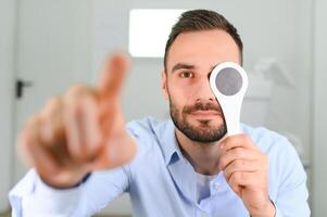 retrato, visión y cuchara con un hombre paciente a el optometrista para un ojo examen pruebas su profundidad percepción foto