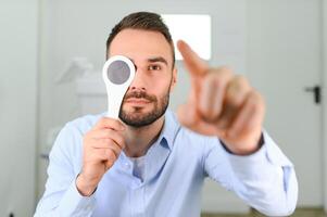 Portrait, vision and spoon with a man patient at the optometrist for an eye exam testing his depth perception photo